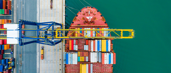 Container ship being loaded by crane.