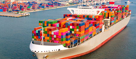 Container ship sailing away from port.